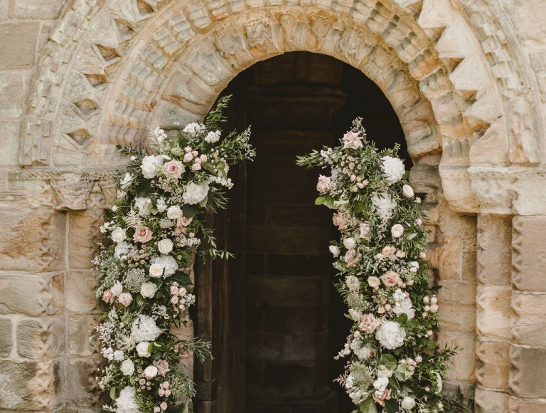 Wedding ceremony entrance to priory with flower arch