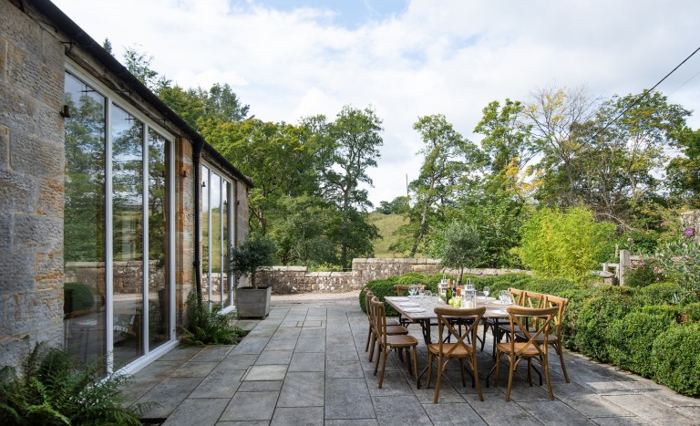 Back garden of The Stables holiday cottage surrounding by woodland at Brinkburn Priory