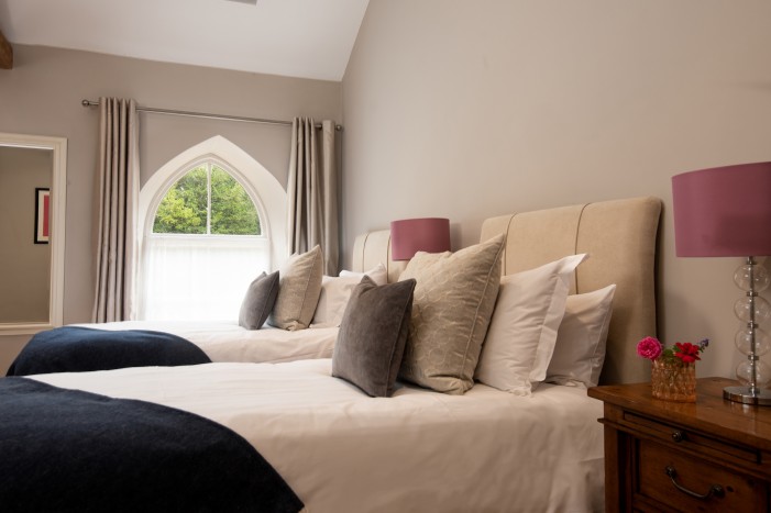 Twin beds in holiday cottage with woodland views of Brinkburn Priory in Northumberland