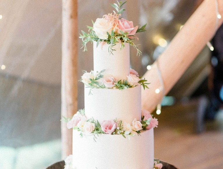 Wedding cake with flowers in rustic tipi at Brinkburn Northumberland