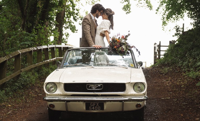 couple in classic car leaving elopement ceremony at Brinkburn Northumberland
