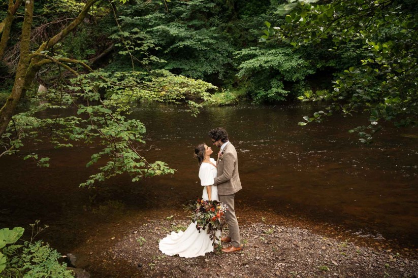 couple on the riverside at Brinkburn Northumberland