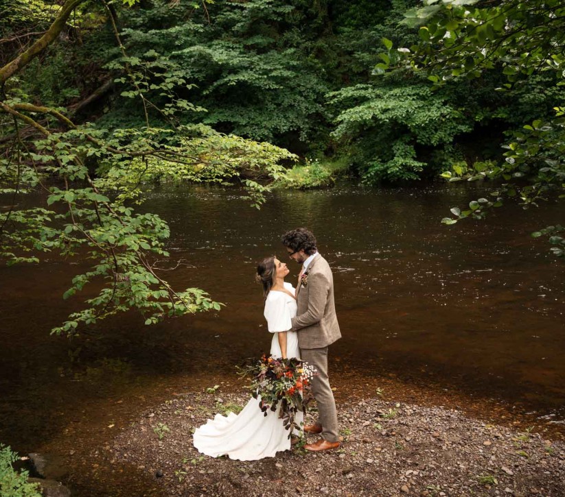 couple on the riverside at Brinkburn Northumberland