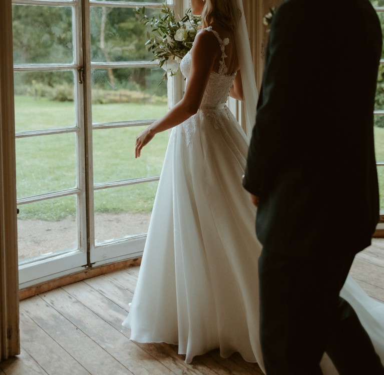 A bride and a groom viewing the Brinkburn manor house lawn