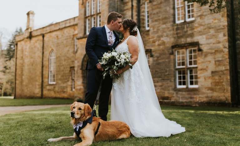Bride and Groom outside The Manor House at Brinkburn Northumberland with their dog