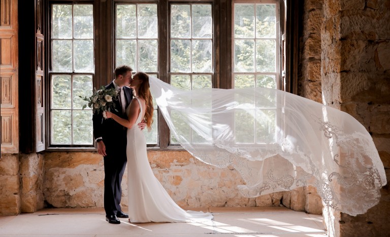Couple in front of rustic windows in the Manor House at Brinkburn Northumberland