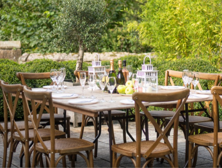 A set wooden dining table and chairs in a garden